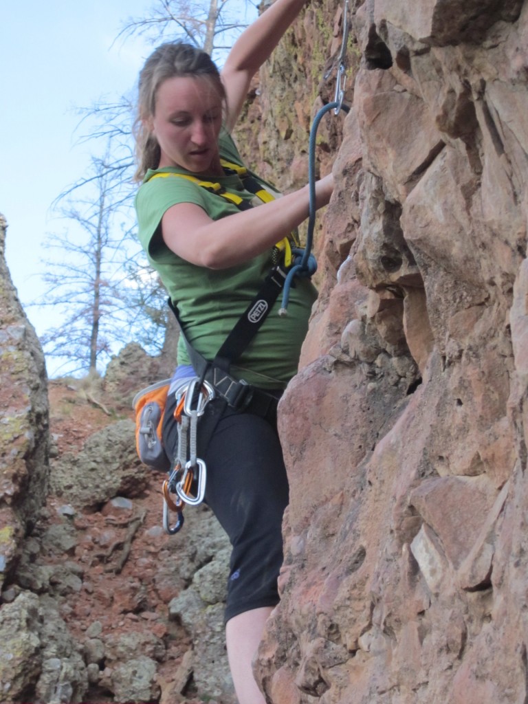 Schauer climbing while pregnant using a full body harness.